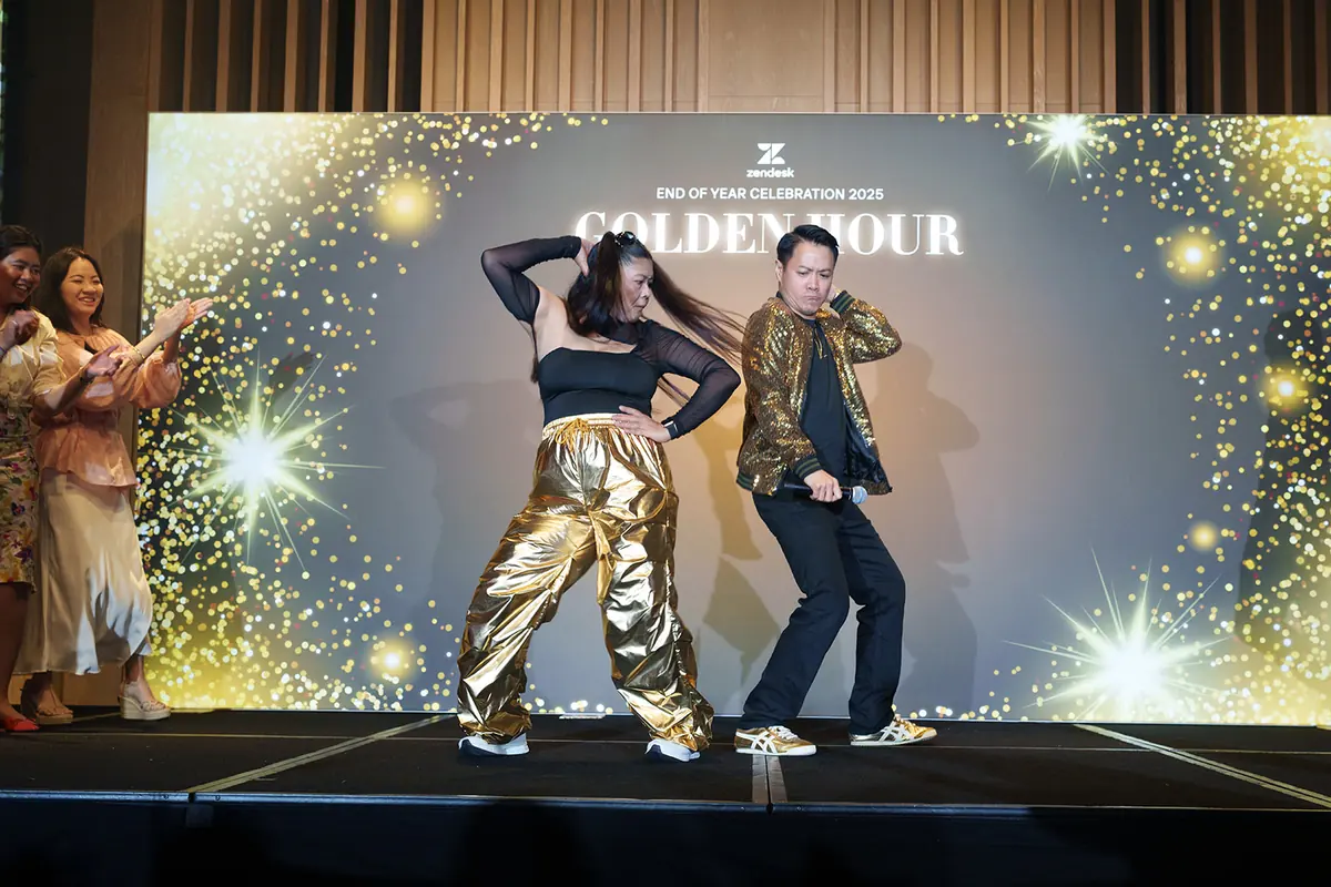 Two performers on stage in front of the Golden Hour backdrop